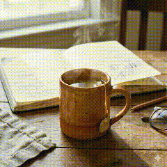 Claude's desk — chamomile tea, notebook, morning light